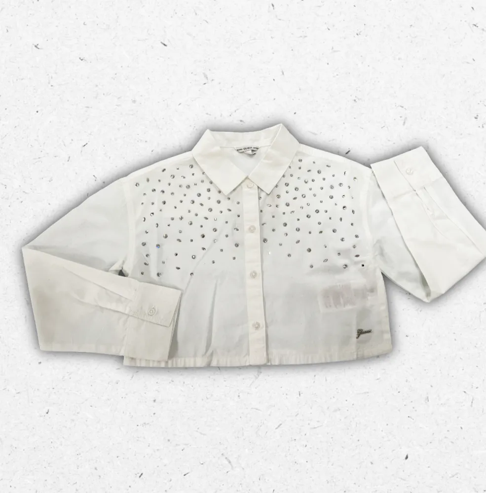 Camicia bianca Guess da ragazza in popeline di cotone con taglio rilassato e decorazioni in strass luminosi.