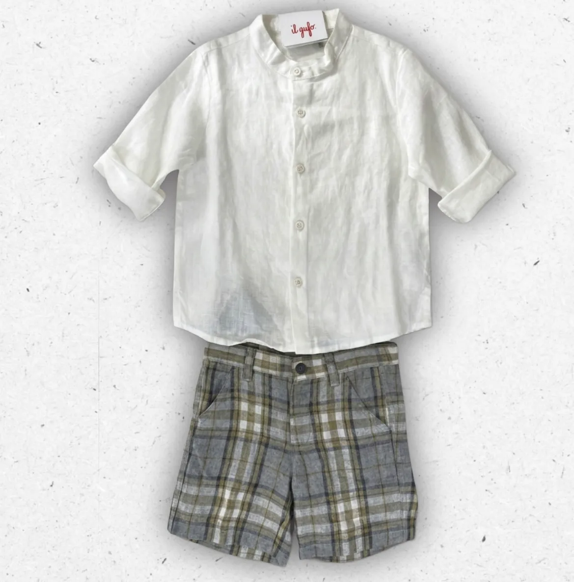 Completo da bambino Il Gufo composto da camicia a maniche corte in cotone seersucker a righe bianche e azzurre con collo alla coreana e bermuda blu navy coordinato.