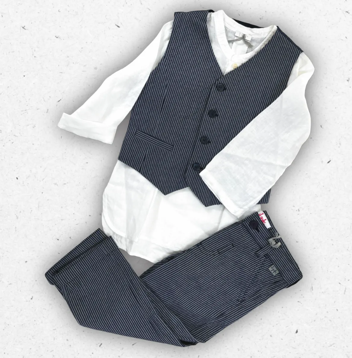 Completo elegante da bambino Il Gufo composto da camicia a maniche lunghe in lino bianco, gilet blu scuro gessato a righe sottili e pantalone coordinato.
