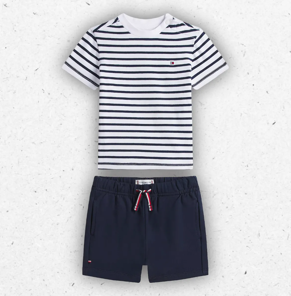 Completo estivo da neonato firmata Tommy Hilfiger composto da t-shirt a maniche corte a righe orizzontali bianche e blu e shorts blu navy coordinati con lacci in vita.