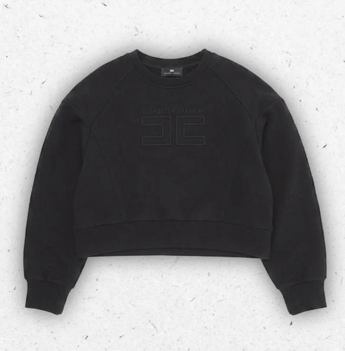 Felpa da ragazza a girocollo modello cropped firmata Elisabetta Franchi, con maniche raglan e logo centrale doppia C ricamato a rilievo tono su tono, disponibile in nero e in giallo.