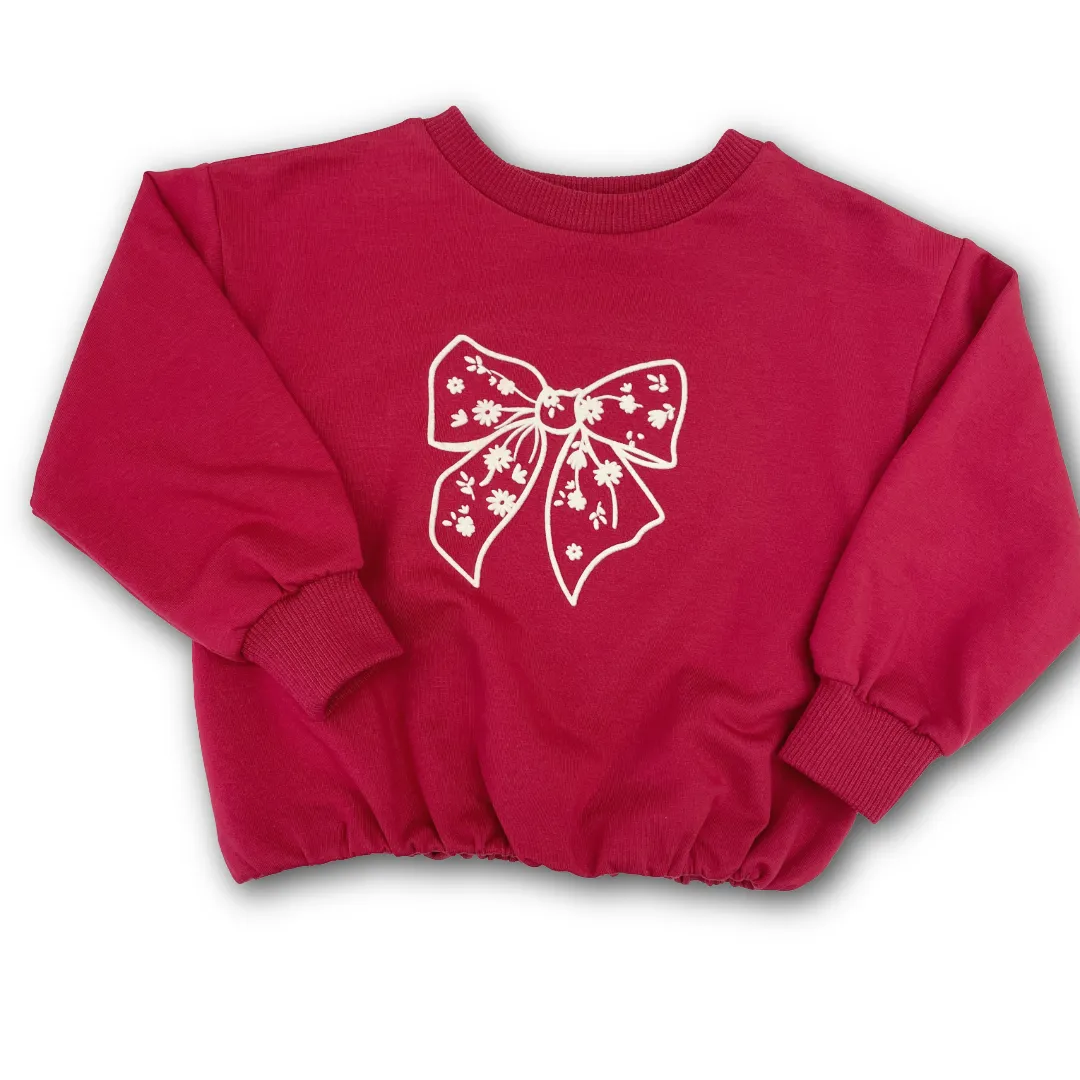 Felpa Please girocollo in colore rosso fucsia per neonata, con stampa di un fiocco floreale.