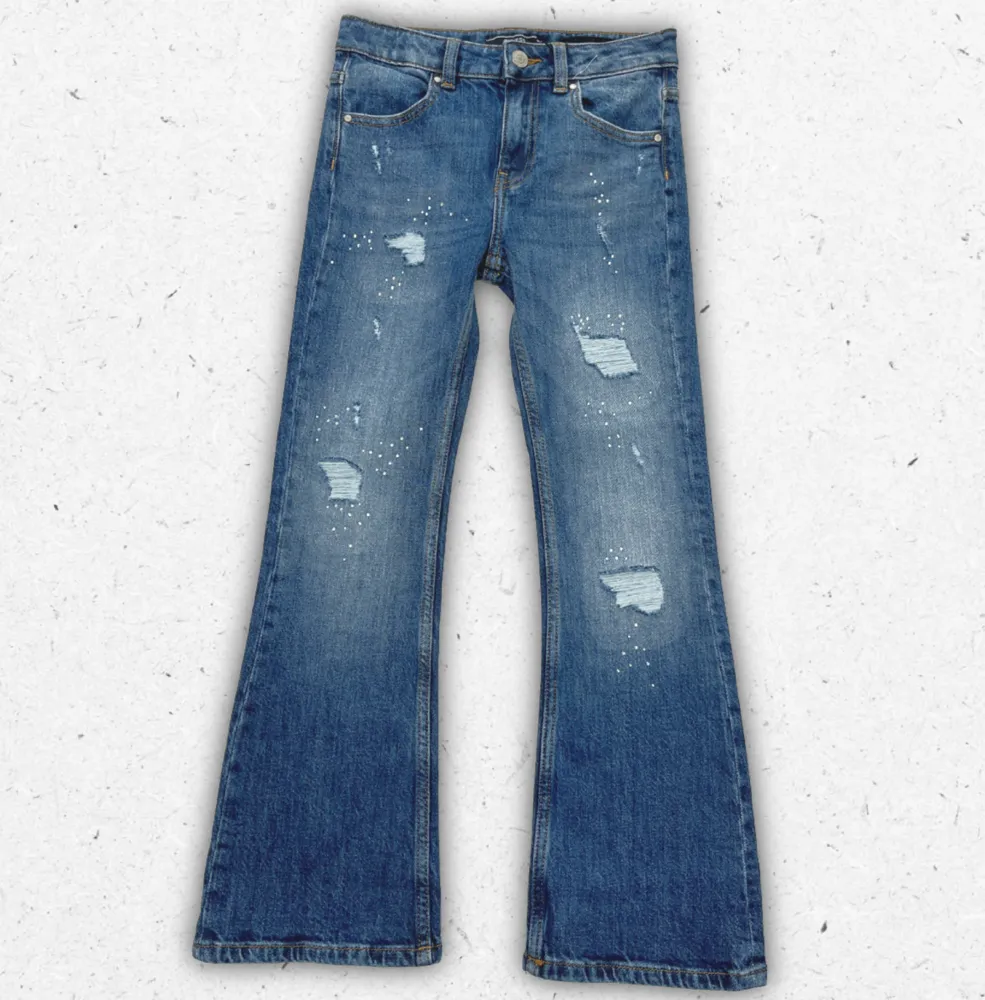 Jeans Guess da ragazza in denim blu con strappi sulle ginocchia, effetto invecchiato e logo a triangolo sulla tasca posteriore.