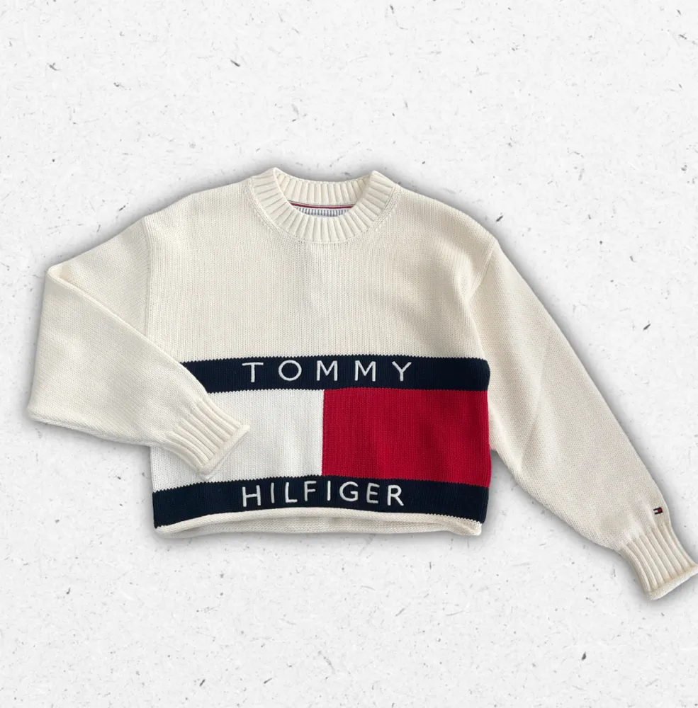 Maglione Tommy Hilfiger da ragazza con lavorazione a trecce, girocollo e logo bandierina ricamato sul petto.