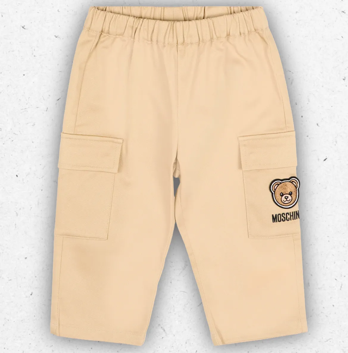 Pantalone modello cargo da neonato firmato Moschino Kids in gabardina di cotone beige con tasche laterali e ricamo dell'orsetto Teddy Bear.