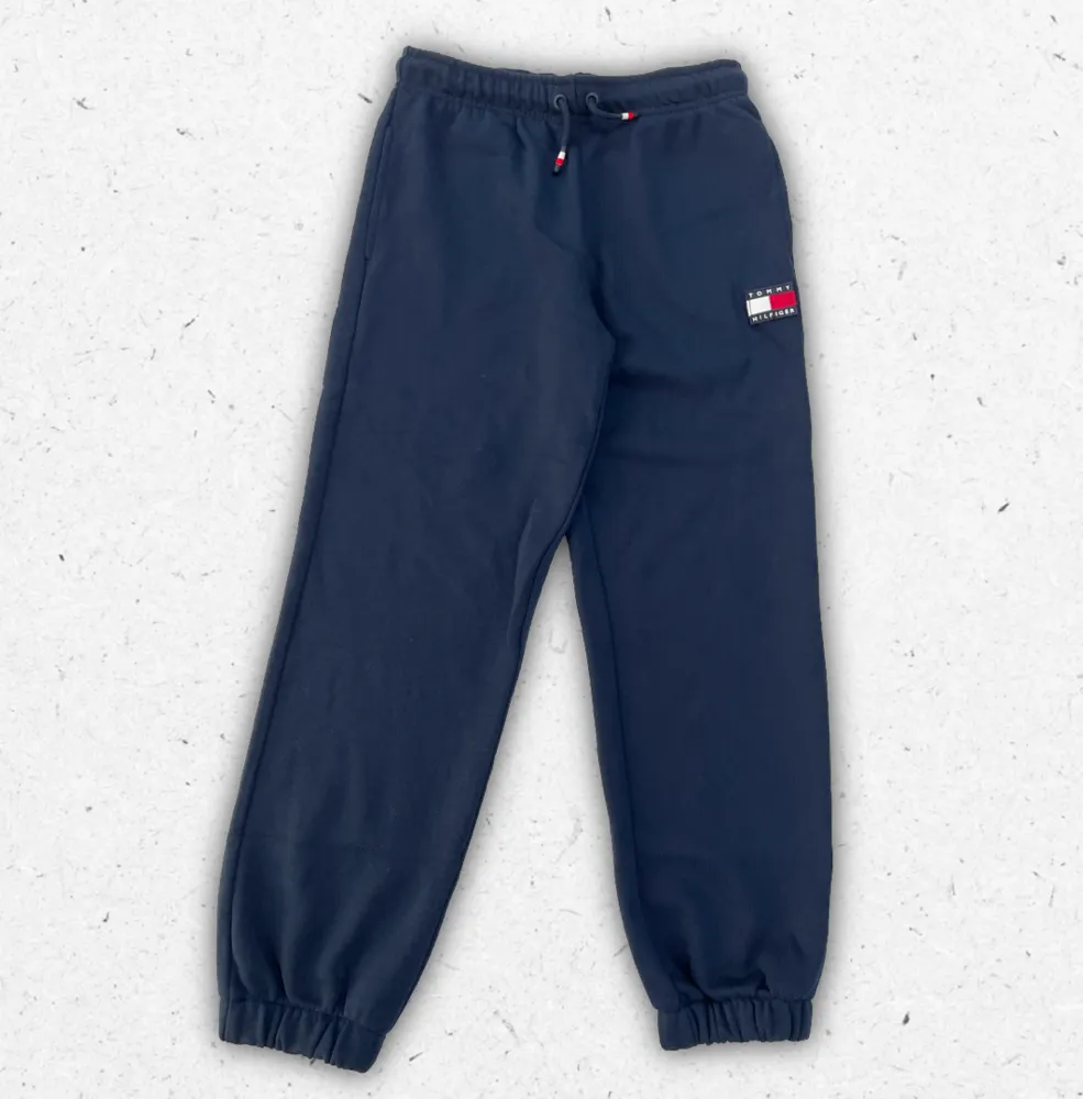 Pantalone jogger Tommy Hilfiger da ragazzo blu navy con elastico alle caviglie, coulisse in vita e patch logo flag sulla gamba.