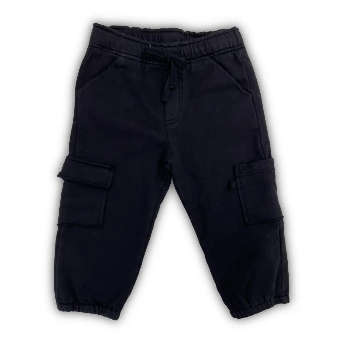 Pantalone tuta Maperò modello cargo per neonato in colore nero, con vita elasticizzata e tasche applicate.