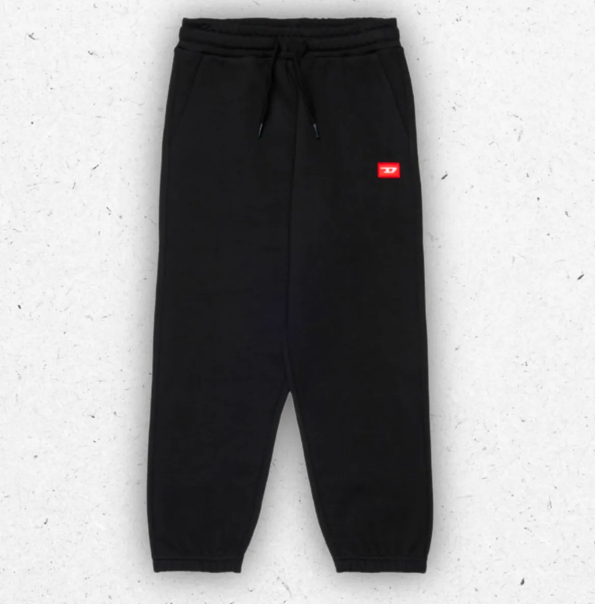 Pantaloni sportivi regular fit da bambino firmati Diesel in cotone, con coulisse in vita, polsini elasticizzati e grandi tasche laterali con logo, collezione Autunno Inverno 2026.