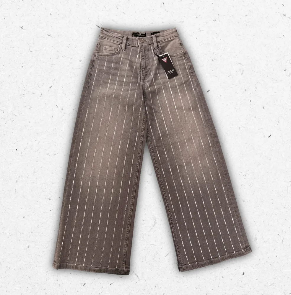 Pantaloni Guess da ragazza in cotone elasticizzato con vestibilità slim, tasche posteriori e iconico logo a triangolo.