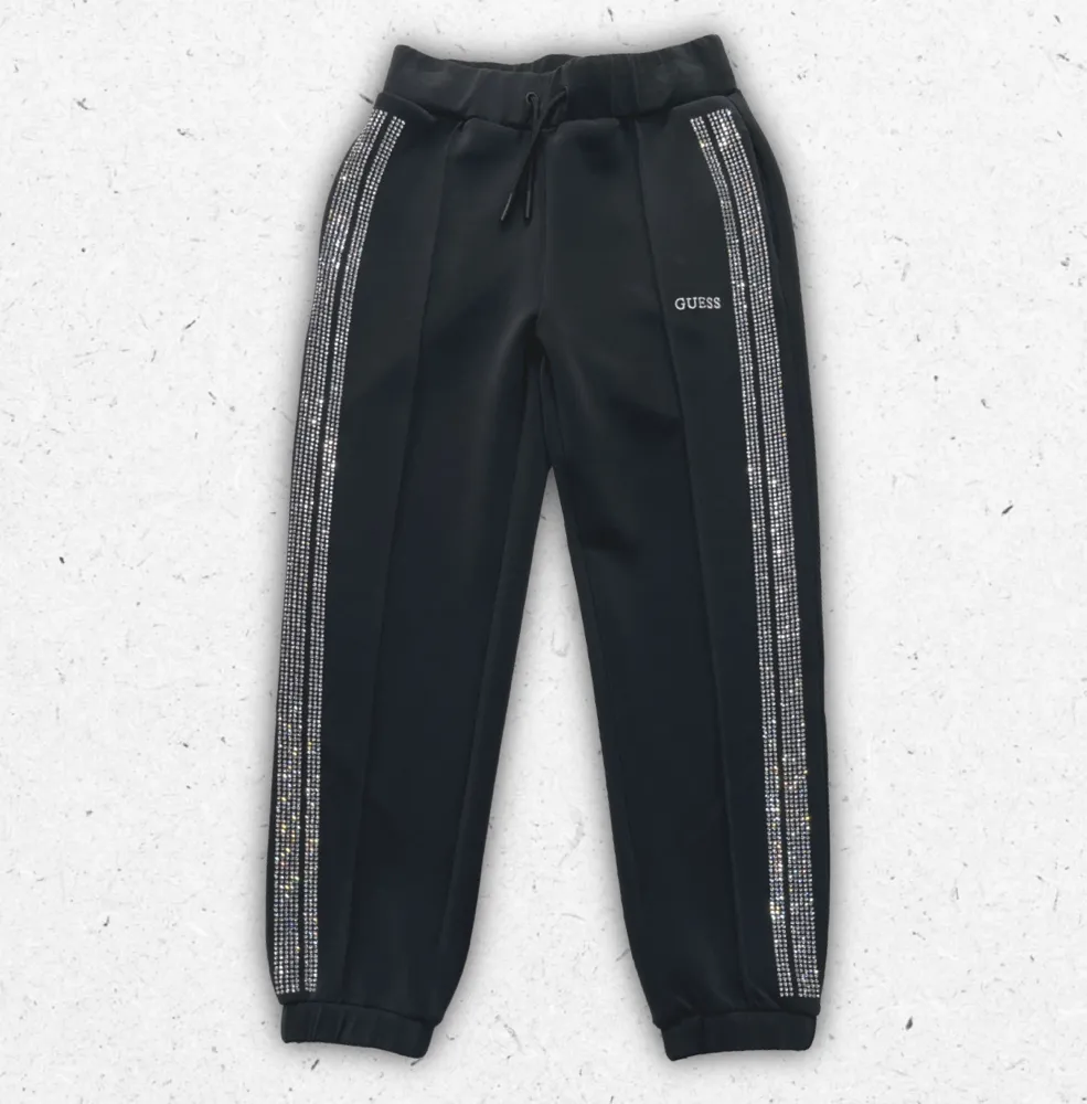 Pantaloni sportivi neri Guess da ragazza modello joggers in cotone con elastico in vita e logo laterale.