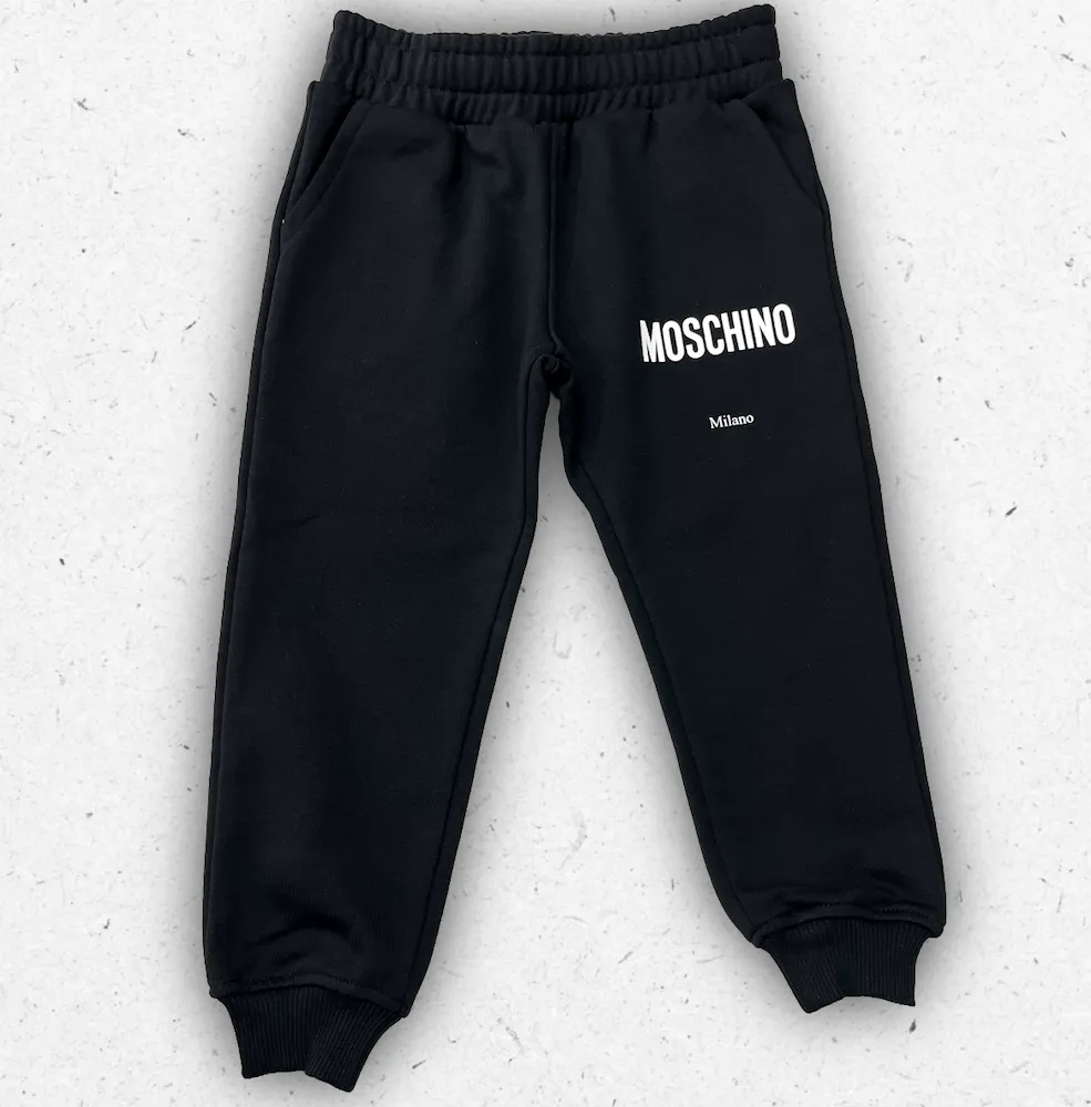 Pantaloni sportivi neri da ragazzo Moschino modello HUP08Y con logo Milano bianco stampato sulla gamba e polsini elasticizzati.