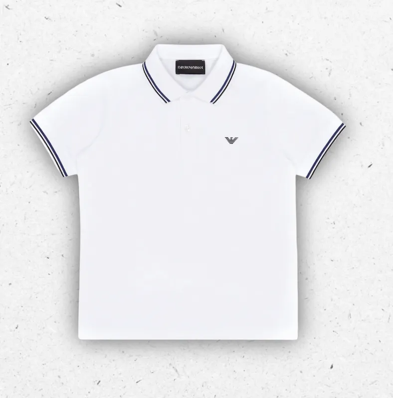 Polo da bambino a maniche corte in piquet di cotone stretch bianco ottico firmata Emporio Armani, con profili del colletto e delle maniche decorati da sottili righe blu scuro a contrasto e logo dell'aquila ricamato sul petto.