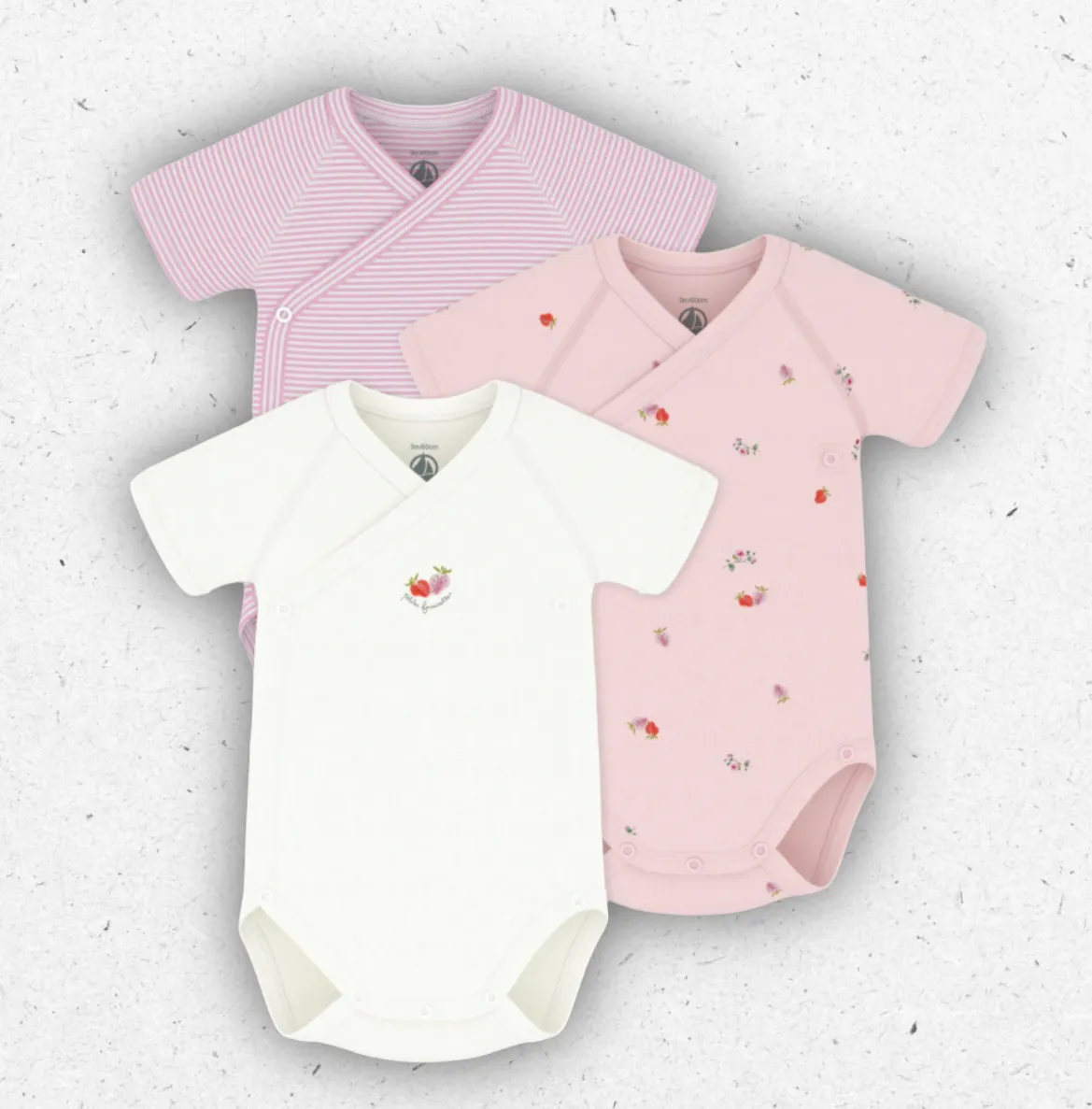Set di tre body da neonata Petit Bateau incrociati a maniche corte con fantasia a stampa, millerighe e tinta unita con serigrafia.