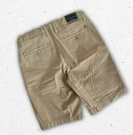 Pantaloncino corto modello chino Tommy Hilfiger da ragazzo in cotone beige con tasche posteriori e bandierina logo ricamata. 1
