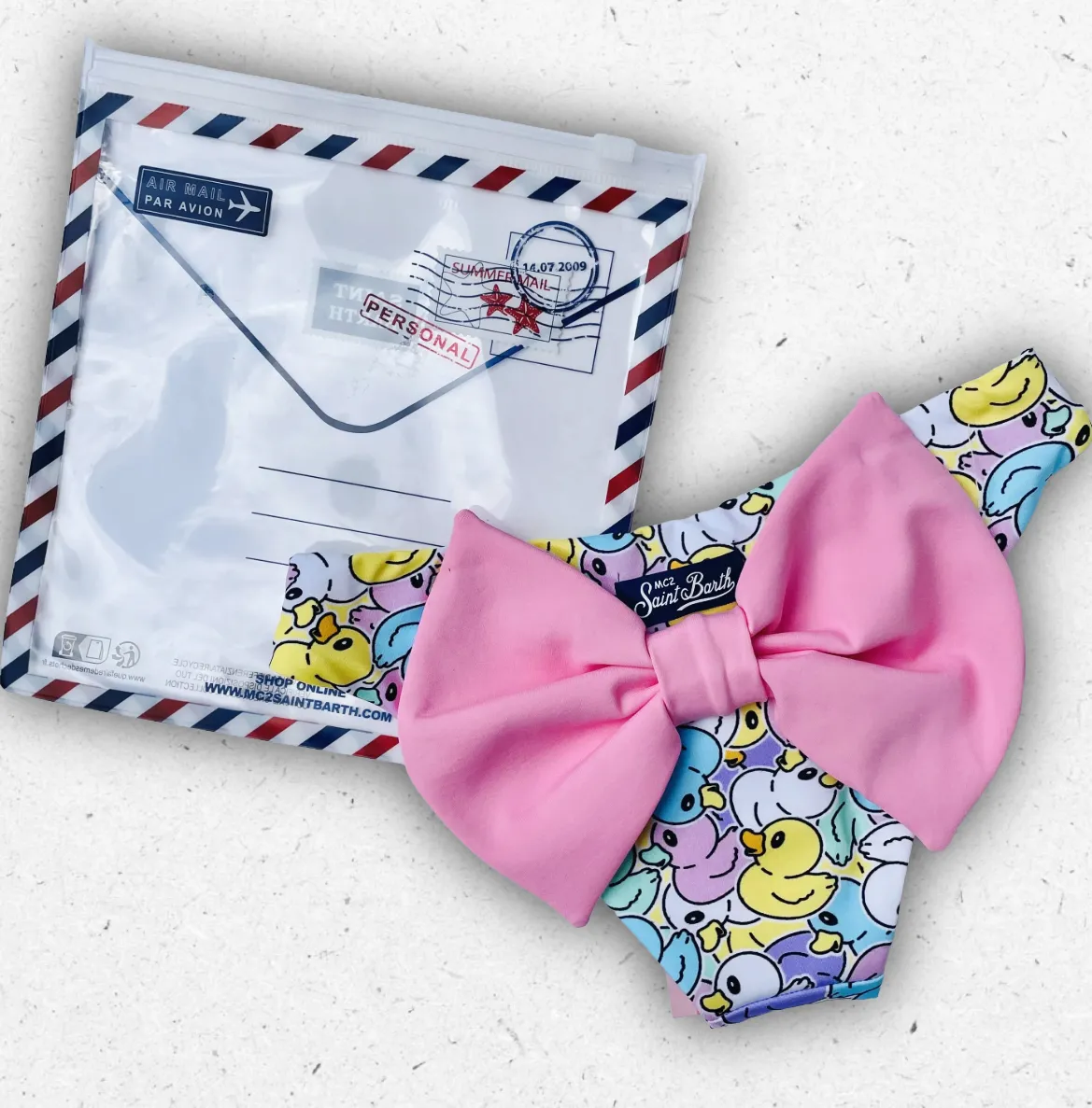 Slip da bagno bambina MC2 Saint Barth modello Madame con fantasia di paperelle gialle e grande fiocco decorativo sul retro.