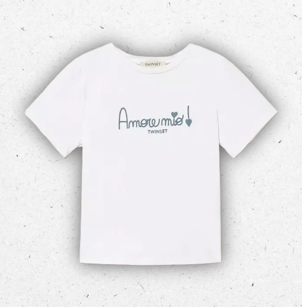 T-shirt bianca Off White da bambina Twinset Milano in cotone con scritta ricamata in azzurro chambray e maniche corte.