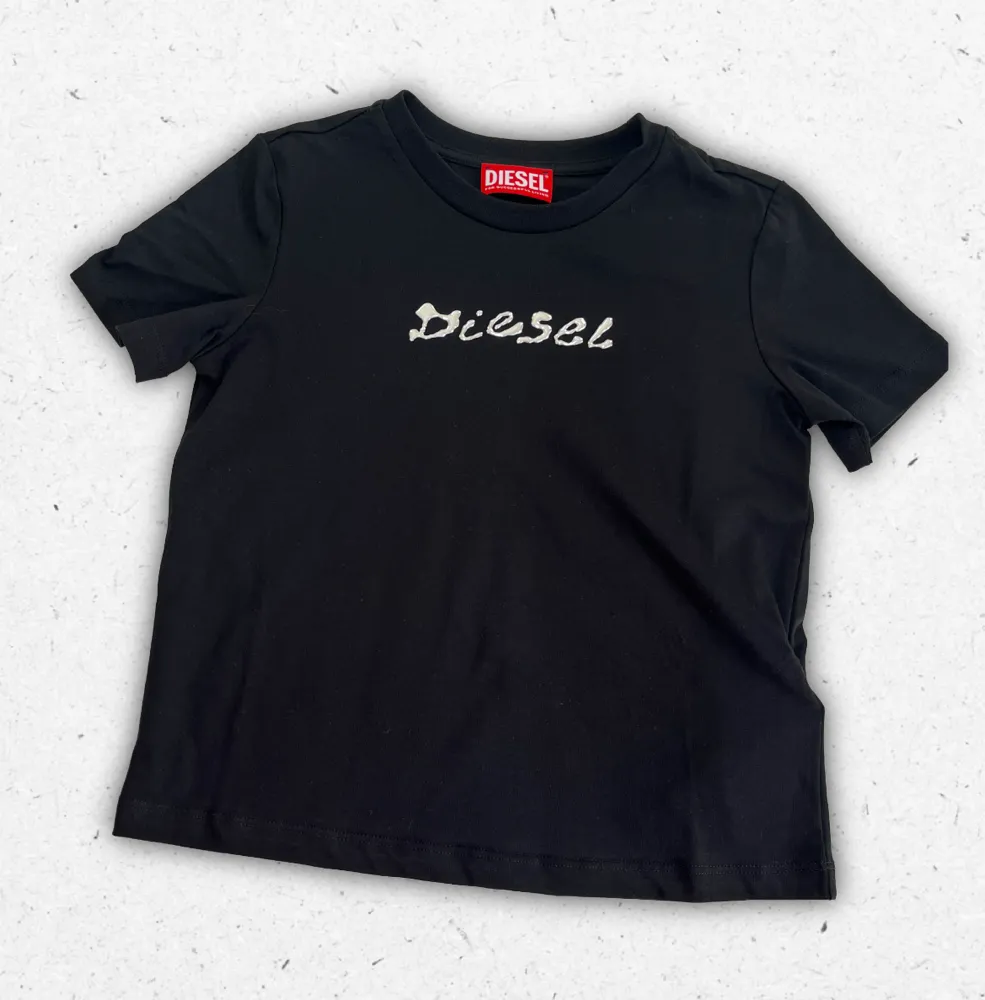 T-shirt Diesel da ragazza in cotone con logo frontale, disponibile nei colori bianco e nero.