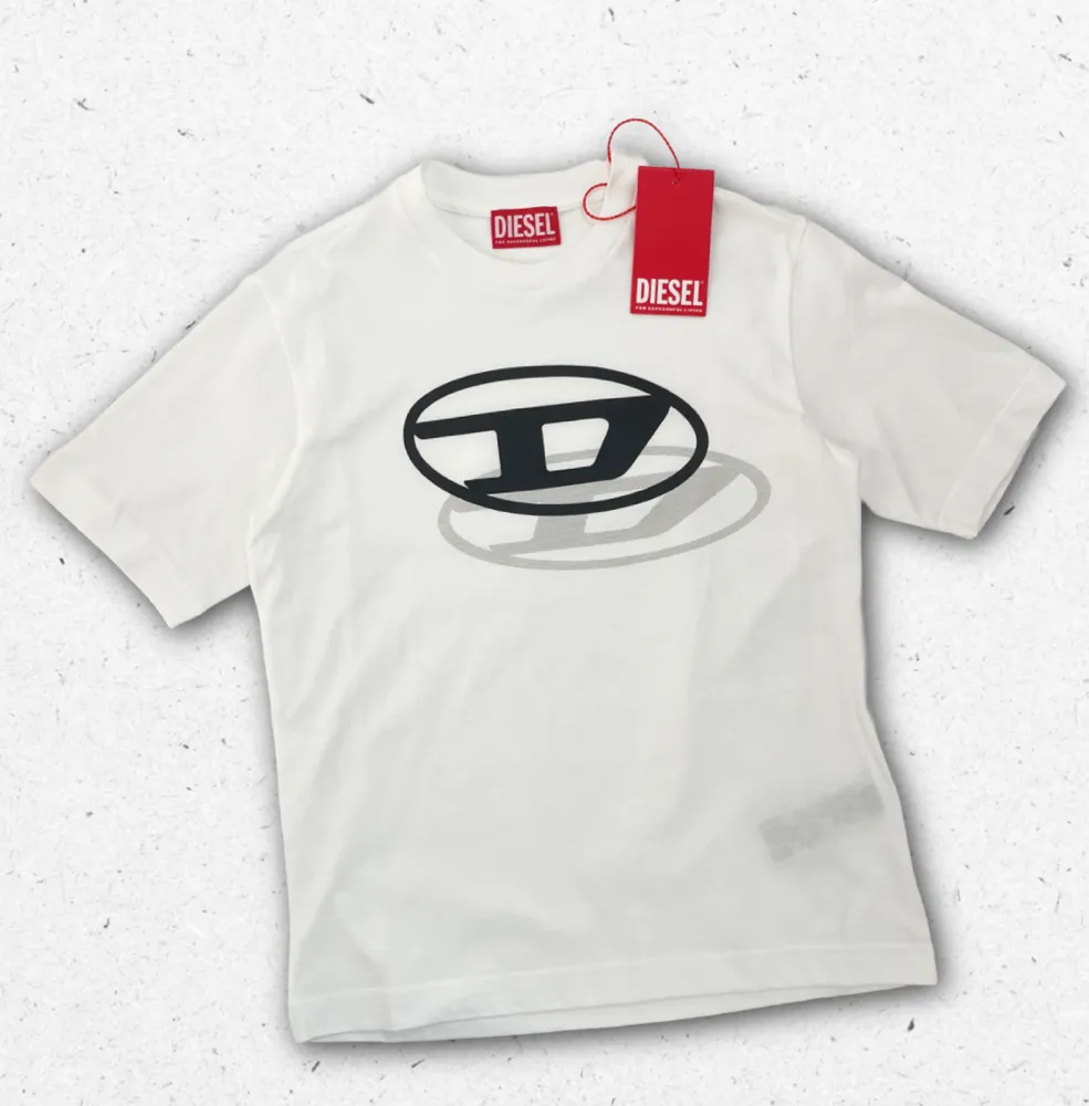 T-shirt Diesel ragazzo in cotone con loghi grafici assortiti (ovale e "D" shadow), disponibile nei colori bianco e nero, Collezione Primavera Estate 2026.