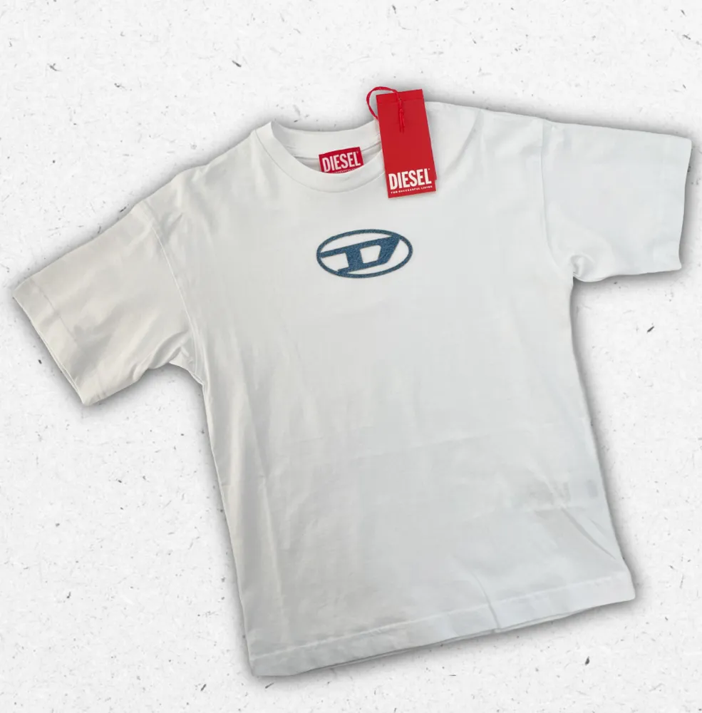 T-shirt Diesel ragazzo in cotone con maxi logo "D" effetto shadow sul petto, disponibile in bianco e nero, Collezione Primavera Estate 2026.