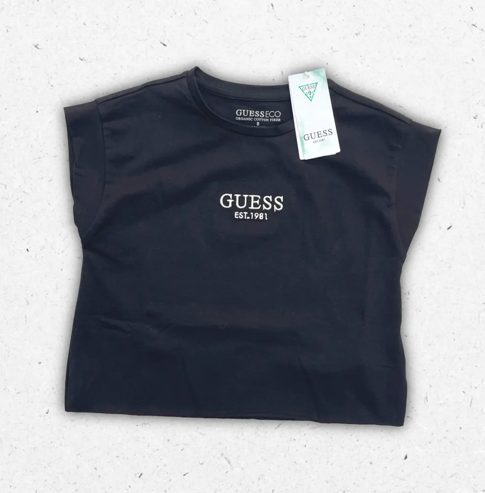 T-shirt Guess da ragazza disponibile nei colori bianco e nero, in puro cotone con logo iconico sul petto.