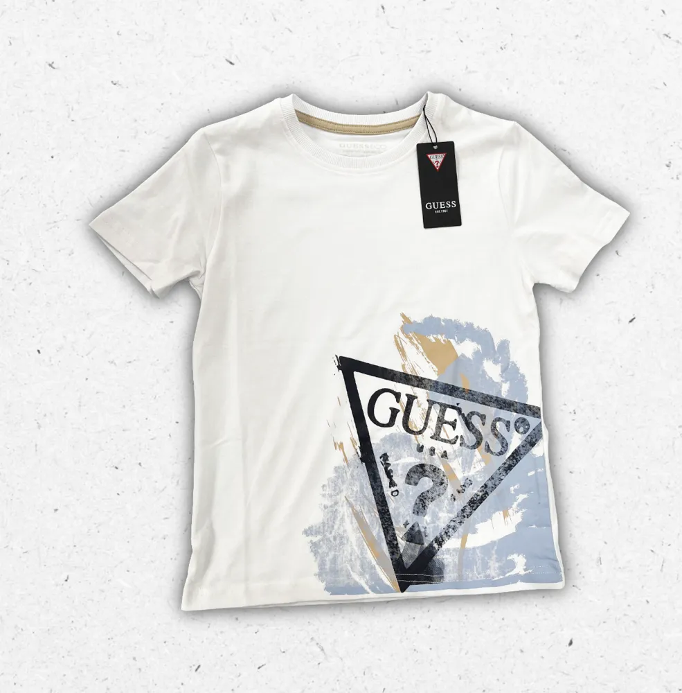 T-shirt Guess da ragazzo in cotone, mostrata nelle varianti blu navy e bianco con logo iconico stampato sul fronte.