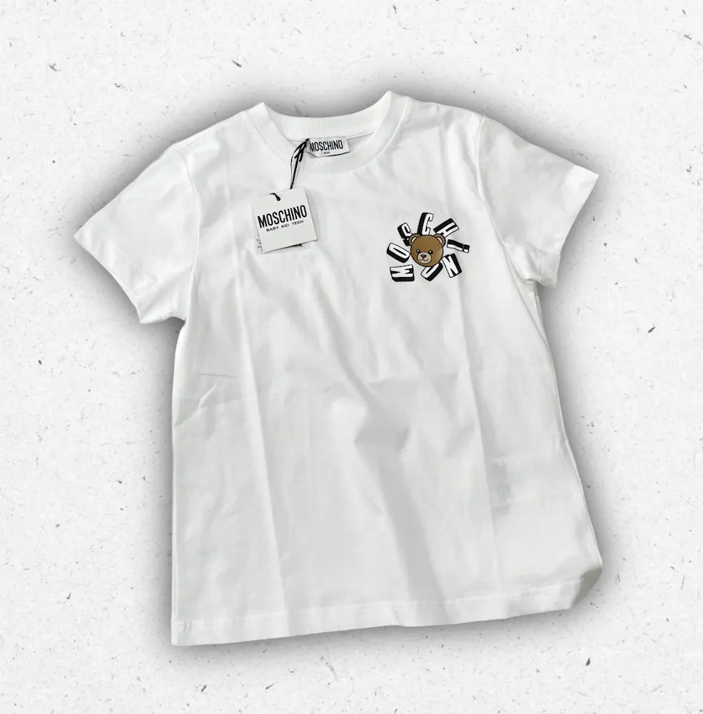 T-shirt bianca da ragazzo Moschino modello HUM05O in jersey di cotone con maxi logo Moschino Milano nero stampato sul petto.